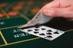 Người chơi đang cầm bài xì dách trên bàn cược với chip đặt phía trước